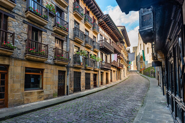 Narrow cobbled streets with flowered balconies and old buildings in the tourist town of...