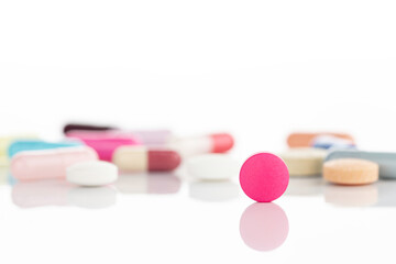 Macro of a pink round pill representing women's health and pharmaceutical treatment. Selective...