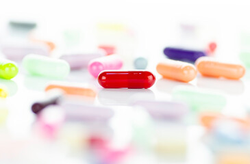 Single red capsule representing a critical medical choice or powerful painkiller drug. This analgesic or antibiotic pill symbolizes modern healthcare, treatment, and pharmaceutical science.