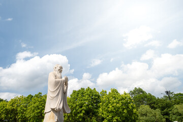 Confucius Statue Under a Blue Sky with White Clouds