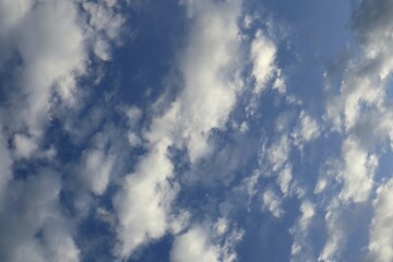 Majestic expanse of the azure sky adorned with ethereal, fluffy white clouds floating freely in