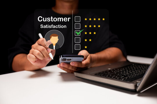 A person rates customer satisfaction on a digital interface using a smartphone and laptop, highlighting a four-star review on a transparent screen.