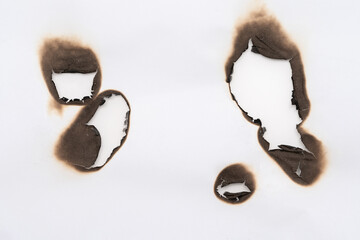 Burnt hole isolated on white paper. burns borders paper close up. Paper burn black stain mark close up.