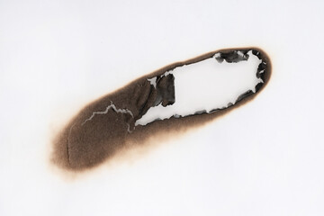 Burnt hole isolated on white paper. burns borders paper close up. Paper burn black stain mark close up.