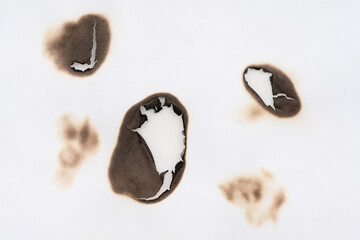 Burnt hole isolated on white paper. burns borders paper close up. Paper burn black stain mark close up.