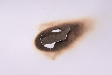 Paper burn black  stain. Round paper burn mark close up. burns borders paper close up