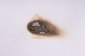 Paper burn black  stain. Round paper burn mark close up. burns borders paper close up
