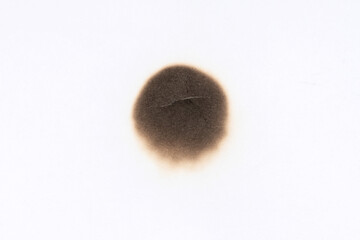 Paper burn black  stain. Round paper burn mark close up. burns borders paper close up