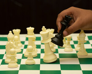 Businessman moving chess piece on chess board game concept for ideas and competition and strategy, business success concept, business competition planning teamwork strategic concept.