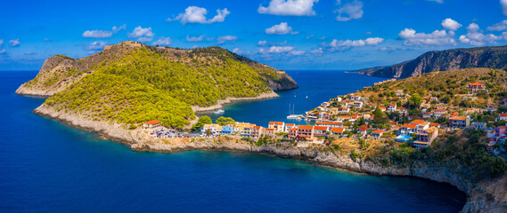Turquoise colored bay in Mediterranean sea with beautiful colorful houses in Assos village in Kefalonia, Greece. Town of Assos with colorful houses on the mediterranean sea, Greece.