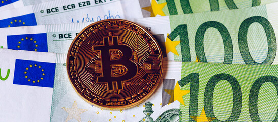 Golden bitcoin over Euro money. Bitcoin cryptocurrency. Crypto currency concept. Bitcoin with euro bills. Bitcoins stacked on euro banknotes.
