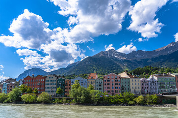 Beautiful view of Colourful Houses on the river side of Inn River with Nordkette mountain in background on a sunny spring day, Innsbruck, Tyrol, Austria