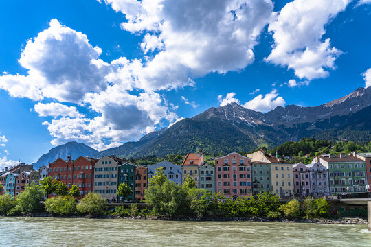 Beautiful view of Colourful Houses on the river side of Inn River with Nordkette mountain in background on a sunny spring day, Innsbruck, Tyrol, Austria