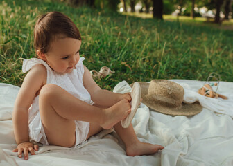 Happy little baby girl playing in a sunny park. Childhood joy, Mother's Day, outdoor activity,...