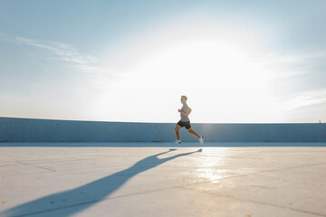 Running towards the sunshine at dawn in an urban environment for fitness