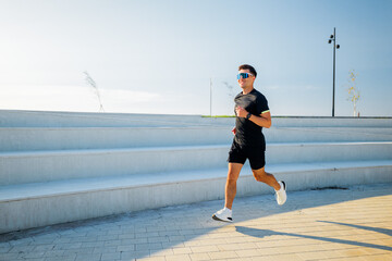 Man running along steps in a sunny outdoor park during morning exercise