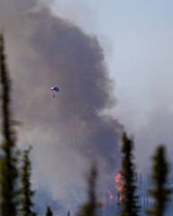 A smokejumper parachutes into a wildfire.