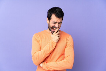 Caucasian handsome man over isolated purple background yawning