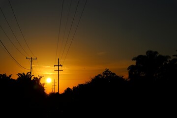Golden Hour Silhouette A Landscape of Electrical Poles and Natural Splendor at Dusk