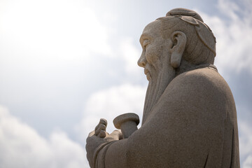 A Contemplative Statue of Confucius Under the Sky