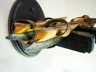 Antique 19th century ice skates lie on a stand