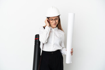 Young architect woman with helmet and holding blueprints isolated on white background frustrated...