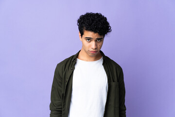Obraz premium Young Venezuelan man isolated on purple background with sad expression
