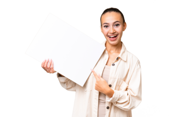Young Arab woman over isolated background holding an empty placard with happy expression and pointing it