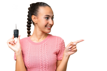 Young Arab woman holding car keys over isolated background pointing to the side to present a product