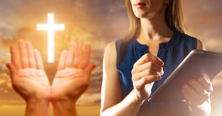 Woman using digital tablet with glowing cross and praying hands overlay, symbolizing modern faith,...