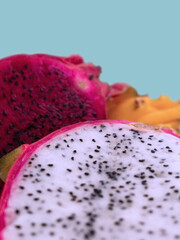 Colorful sliced dragon fruits on pastel blue background – vibrant tropical fruits for concepts related to exotic nutrition, healthy lifestyle, vegan food, wellness, and summer freshness