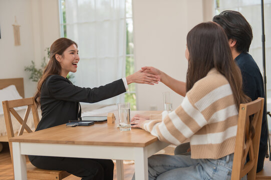 Asian financial consultant explaining new project investment to young couple in office. Real estate agent discussing mortgage options with family. Mortgage loan consultation.