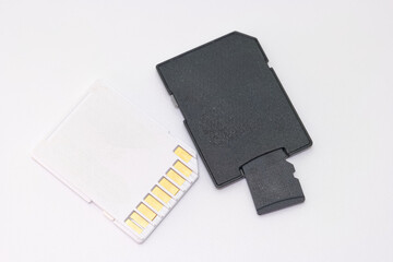 Storage card and adapter on white background for data transfer and memory expansion in electronic...