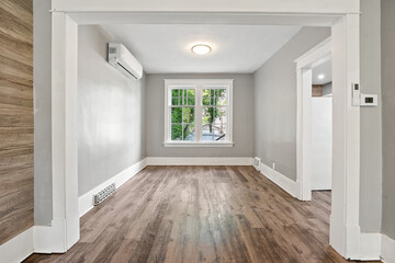 Large open room with a white wall and wooden floor