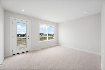 Fototapeta premium Large, empty room with a white door and two windows