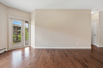 Fototapeta premium Large, empty room with a wooden floor and a door