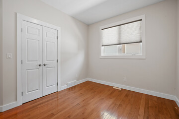 Small, empty room with a white door and a window