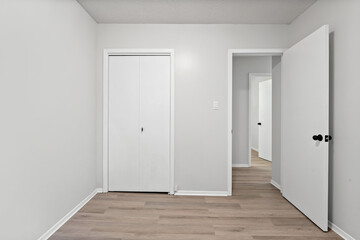 White room with a white door and a white closet