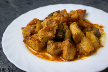 Hearty Stewed Pork with Eggplant and Tomato Sauce on a White Plate