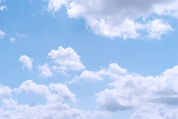 Bright daytime sky filled with scattered cumulus clouds, creating a soft and airy cloud texture...