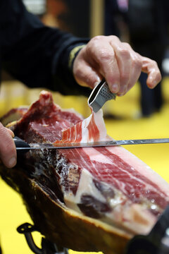 experto cuchillero jamonero cortando una loncha de jam&oacute;n ib&eacute;rico con un cuchillo de cortar jam&oacute;n y su pinza para coger la loncha