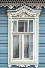 Fragment of the facade of a wooden russian house of the 19th century with carved decor based on...