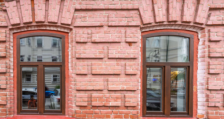 Obraz premium Two windows of the old mansion 19 century with brown bricks wall