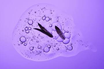 A drop of shampoo with bubbles. A texture with a leaf in it.