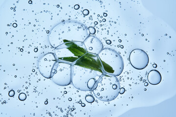 A drop of shampoo with bubbles. A texture with a leaf in it.