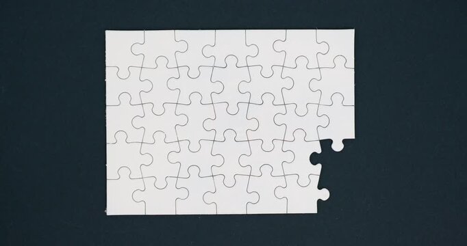 White puzzle on dark gray background. 4K looped stop motion animation
