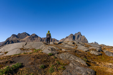 Female hiker enjoying the view of Vestrahorn mountain in Iceland on a beautiful sunny spring day
