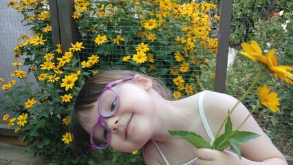 Series of photos of a little girl and yellow flowers. Cheerful childhood, funny emotions