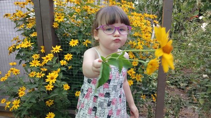 Series of photos of a little girl and yellow flowers. Cheerful childhood, funny emotions