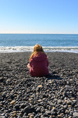 Small girl watching the beautiful ocean view at Reynisfjara black sand beach in Iceland